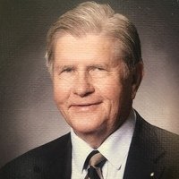 photo of man smiling in front of brown background